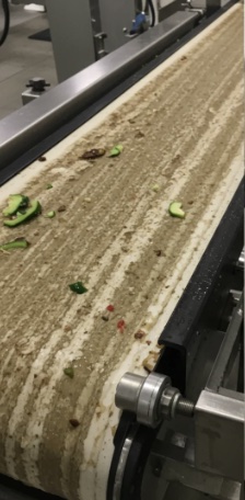Conveyor belt caked with food residue before cleaning